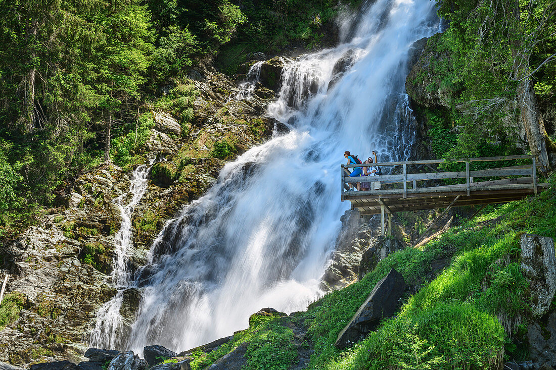 Mehrere Personen stehen auf Aussichtsplattform vor Sintersbach-Wasserfall, Sintersbachwasserfall, Kitzbüheler Alpen, Tirol, Österreich