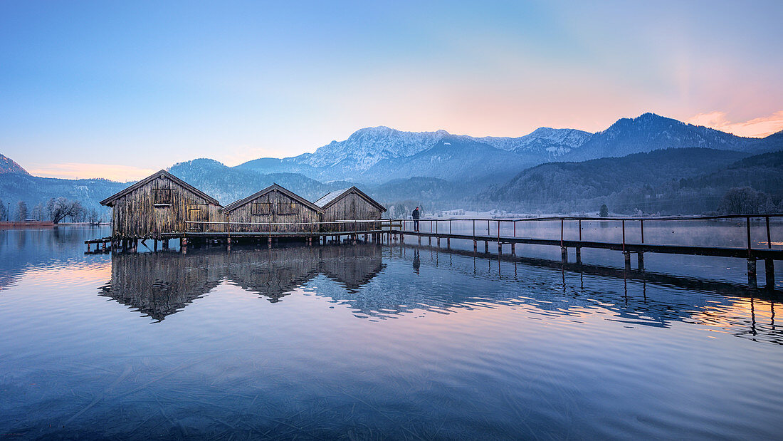 Boat huts at sunset at Kochelsee with jetty, Schlehdorf, Bavaria, Germany