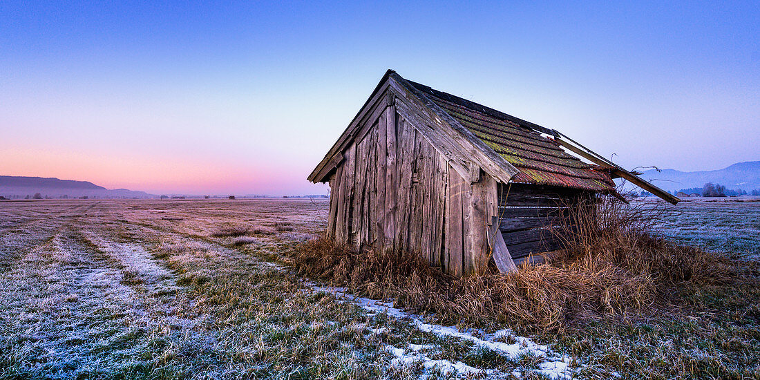 Zerfallene Scheune im Blauen Land bei Sonnenuntergang im Winter, Grossweil, Bayern, Deutschland