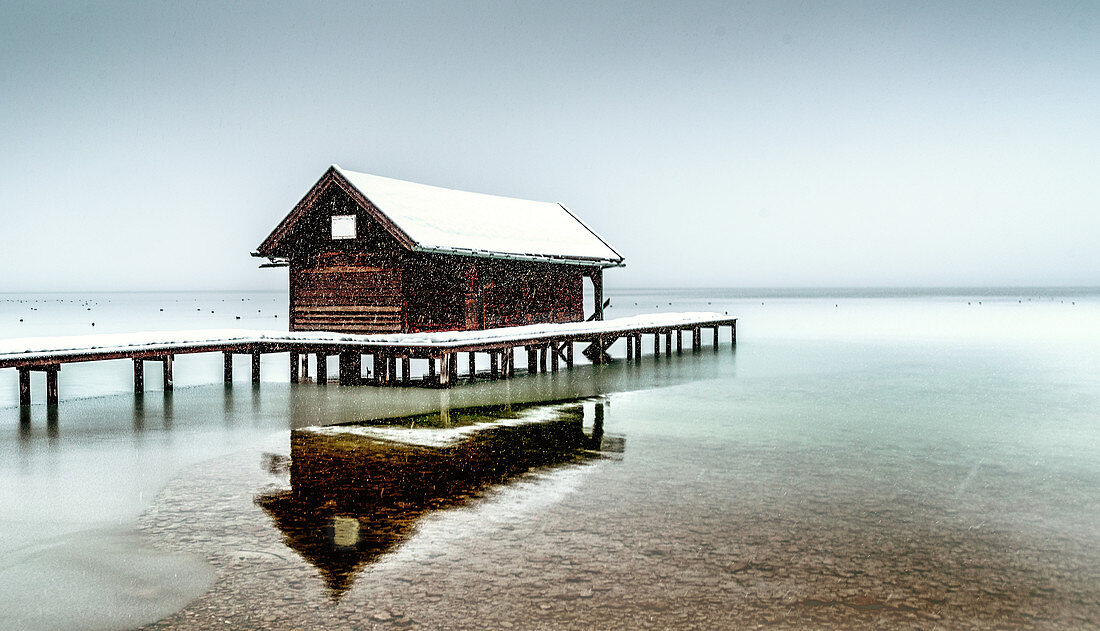 Boathouse during snowfall on Lake Starnberg, Tutzing, Bavaria, Germany