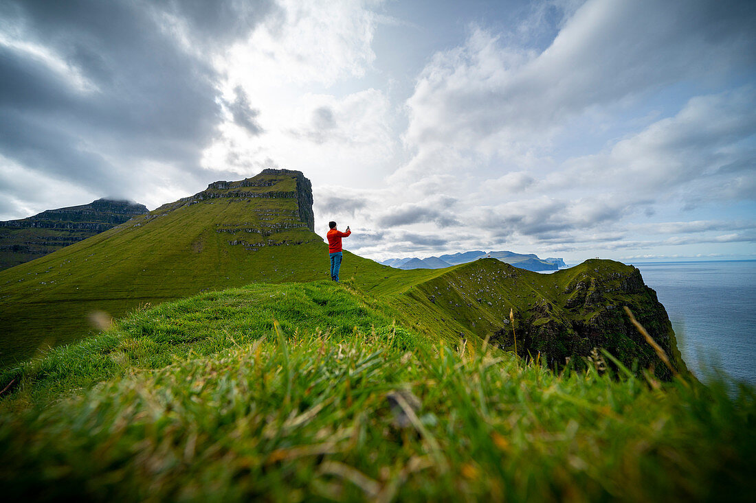 Hiker at Cape Kallur, northern tip of the island Kalsoy, Faroe Islands