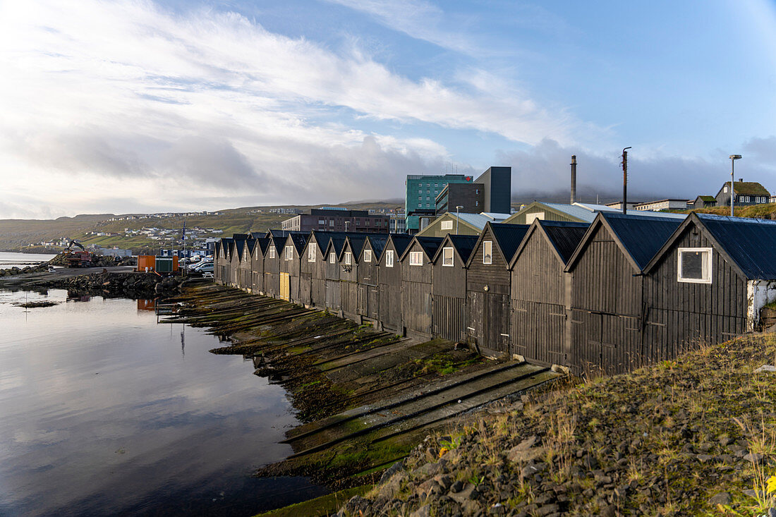 Schwarze Fischerboothütten im Hafen von Thorshavn, Färöer Inseln