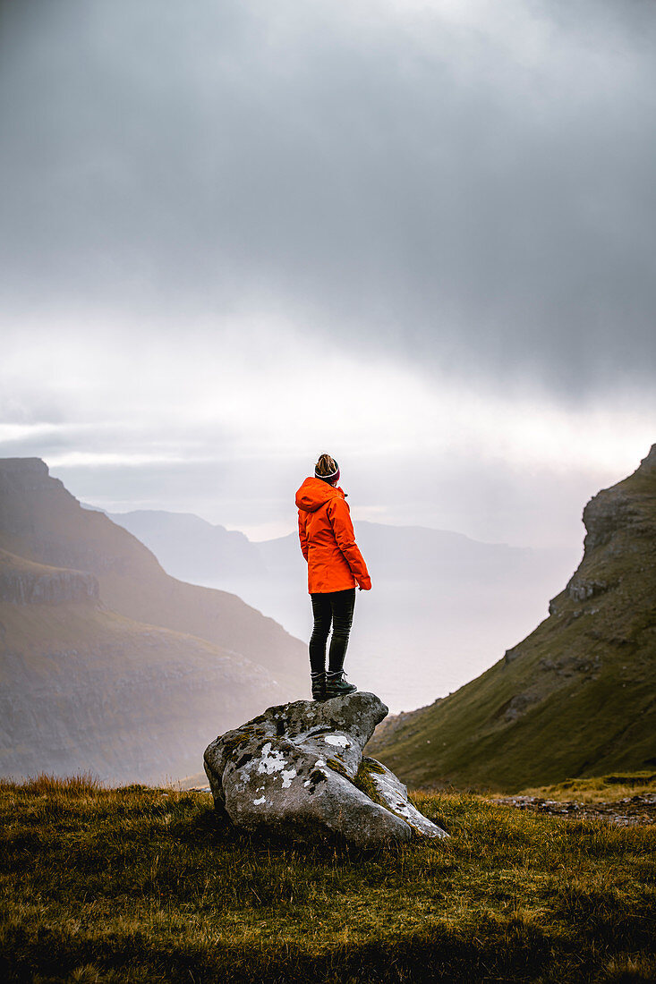 Wandererin genießt den Ausblick auf die herrliche Landschaft der Färöer Inseln