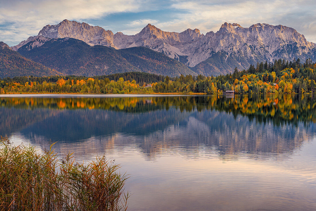 The Karwendel Mountains are reflected in the autumnal Barmsee, Krün, Bavaria, Germany