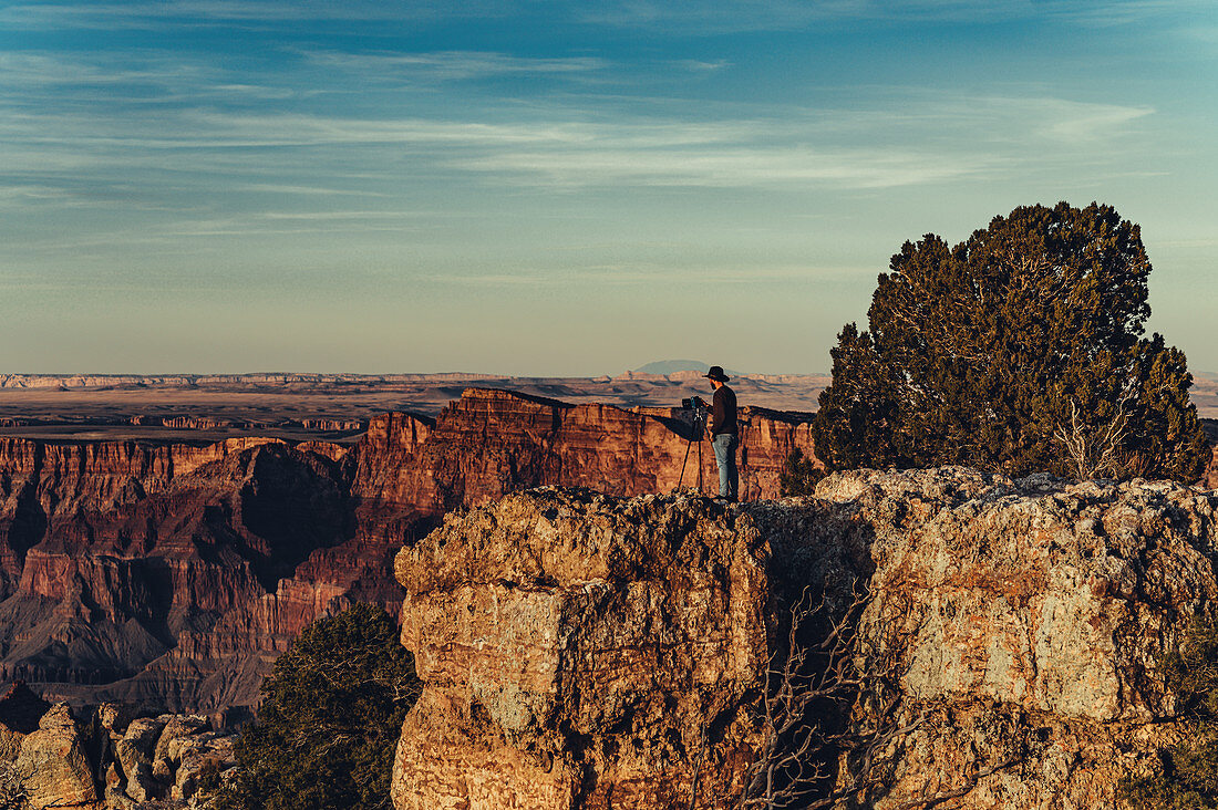 Photographer stands at the rim of the Grand Canyon, Grand Canyon National Park, Arizona, USA, North America
