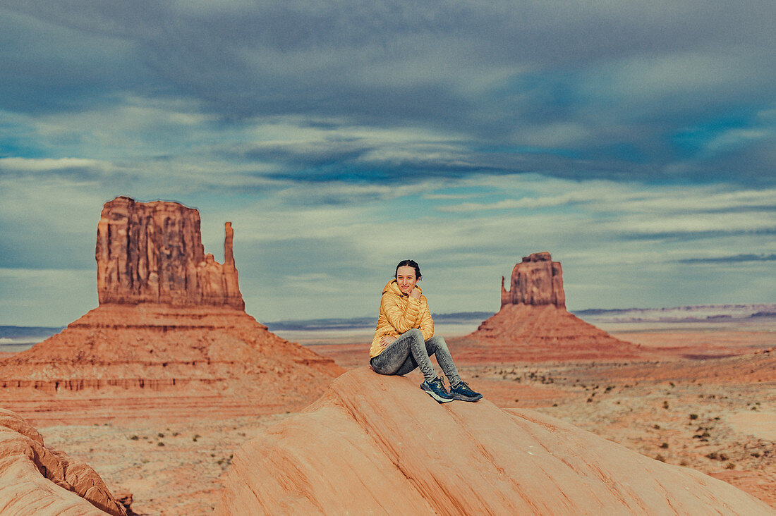 Frau sitzt vor dem Monument Valley, Arizona, Utah, USA, Nordamerika