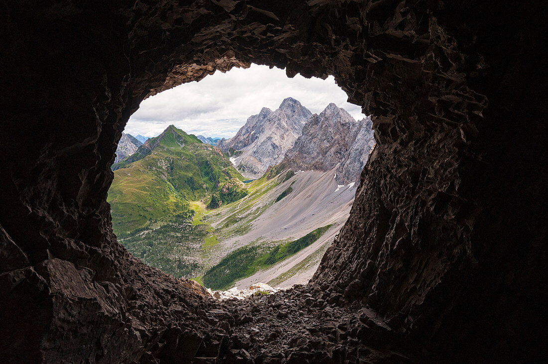 Rauchkofel, Coglians und Lastrons del Lago mit Wolayer See, von einer Kriegshöhle auf dem Kamm des Volaia-Berges, Karnische Alpen, Gruppe Volaia-Berge, Forni Avoltri, Provinz Udine, Friaul-Julisch Venetien, Italien