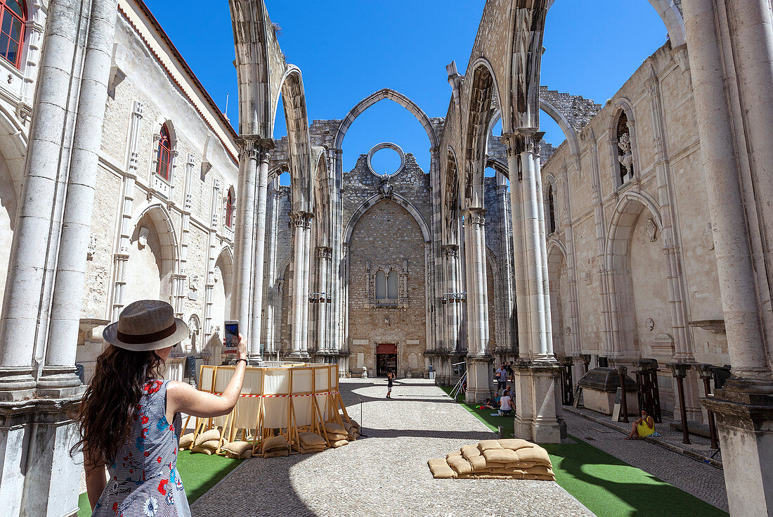 A tourist takes a shot of interior of Igreja do Carmo (Carmo Convent), Chiado Neighborhood, Lisbon, Lisbon Metropolitan Area, Portugal. The roof of the curch collapsed after 1755 heartquake.