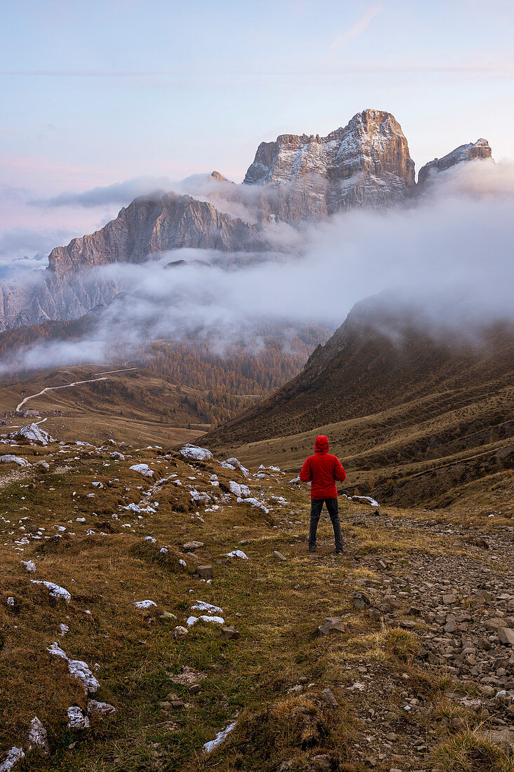 Italy,Veneto,Belluno district,Selva di Cadore,hiker admires Mount Pelmo sticking out of the clouds