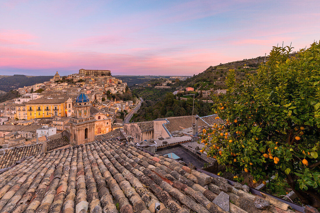 Nahaufnahme eines typischen Daches mit Ragusa Ibla im Hintergrund bei Sonnenuntergang, Ragusa, Sizilien, Italien