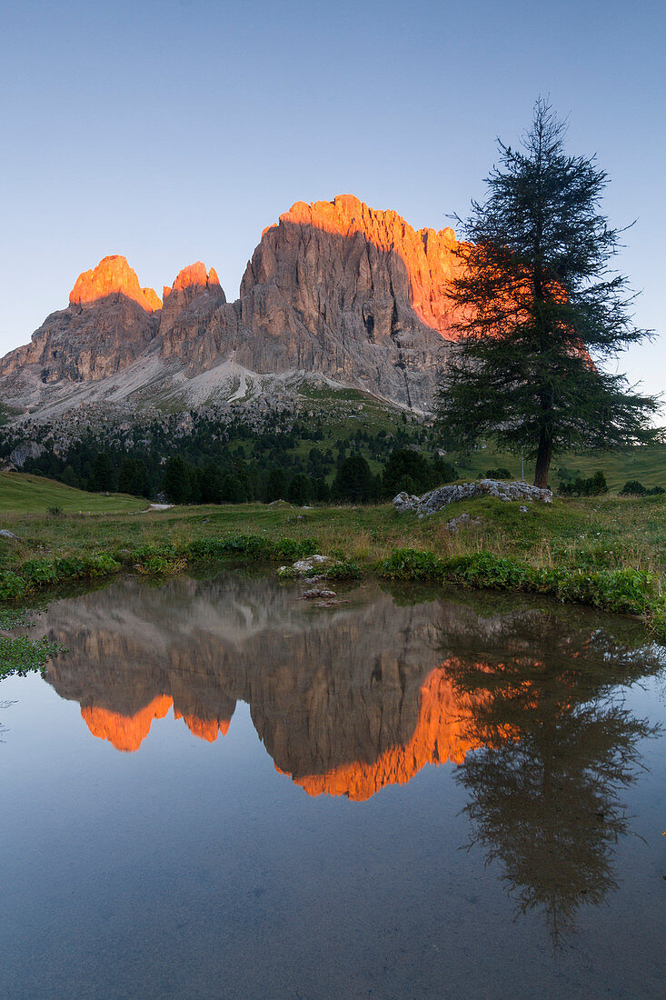 Langkofel bei Sonnenaufgang spiegelt sich im Wasser, Sella Pass, Dolomiten, Trentino, Italien