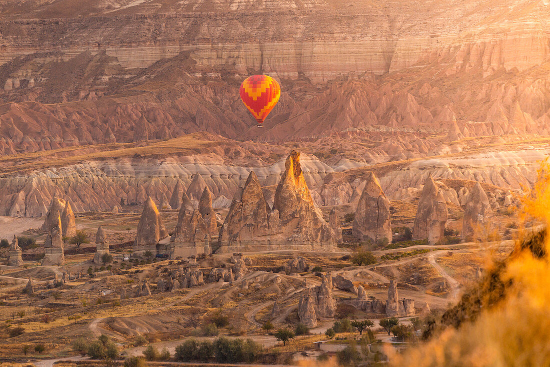 Heißluftballons bei Sonnenaufgang über Felsformationen von Göreme, Rosental, Göreme, Capadocia, Kaisery Bezirk, Anatolien, Türkei
