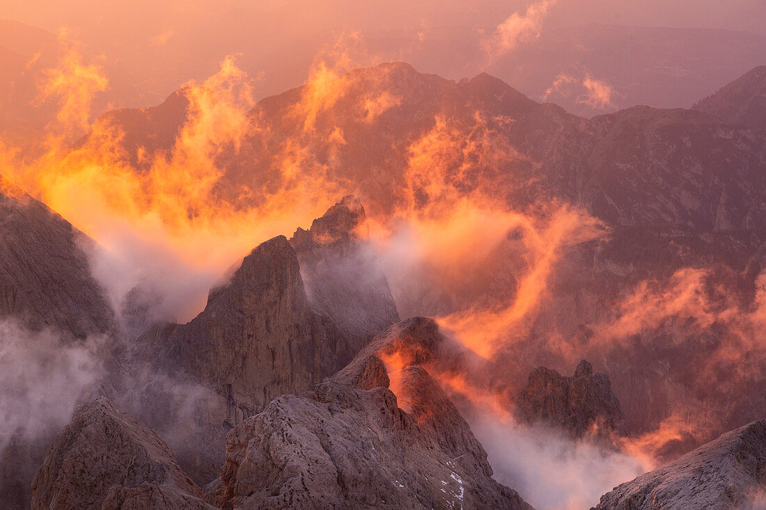 Rote Wolken bei Sonnenuntergang in der Rosengartengruppe über Berggipfeln, Fassatal, Dolomiten, Trentino-Südtirol, Italien, Europa