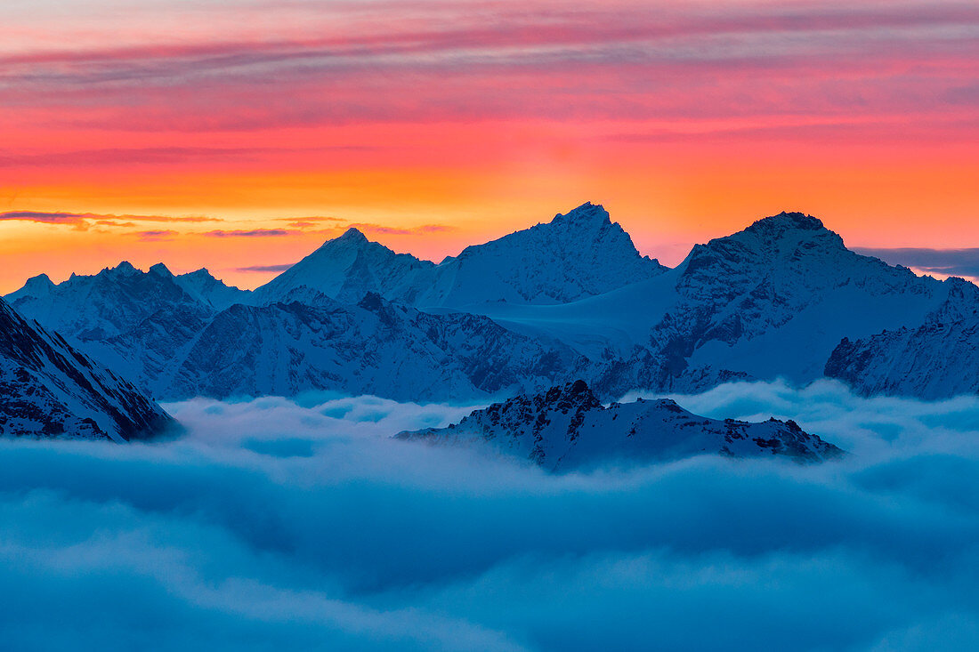 Weisshorngipfel über einem Wolkenteppich bei Sonnenaufgang im Winter in den Schweizer Alpen, Refuge Igloo des Pantalons Blancs, Heremence, Sion, Kanton Wallis, Schweiz, Europa