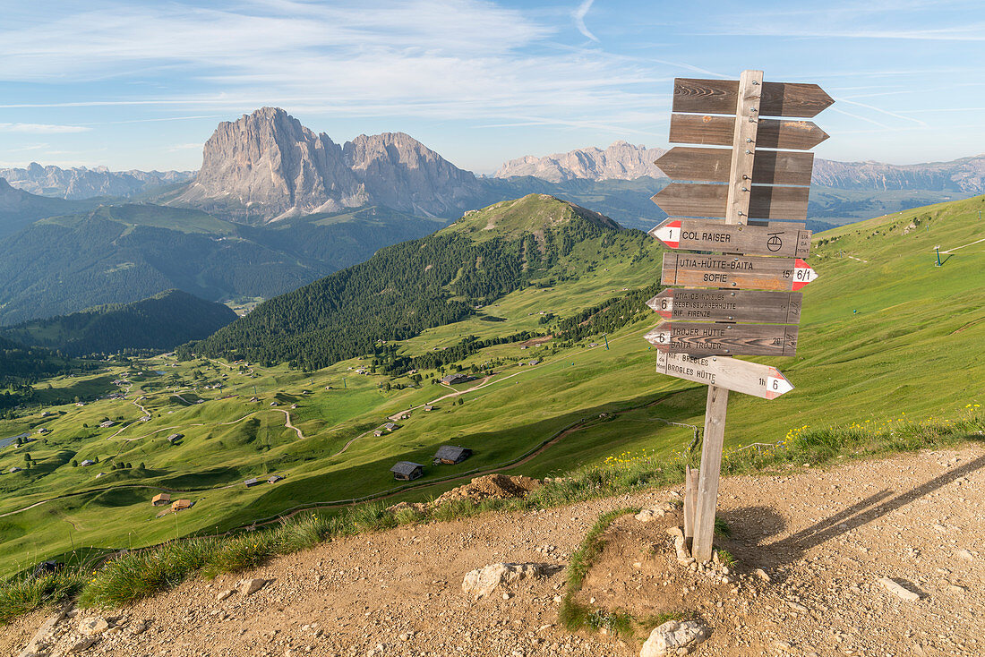 Trail signpost at Seceda, with Langkofel and Plattkofel in the background. Ortisei, Bolzano province, Trentino Alto Adige, Italy.