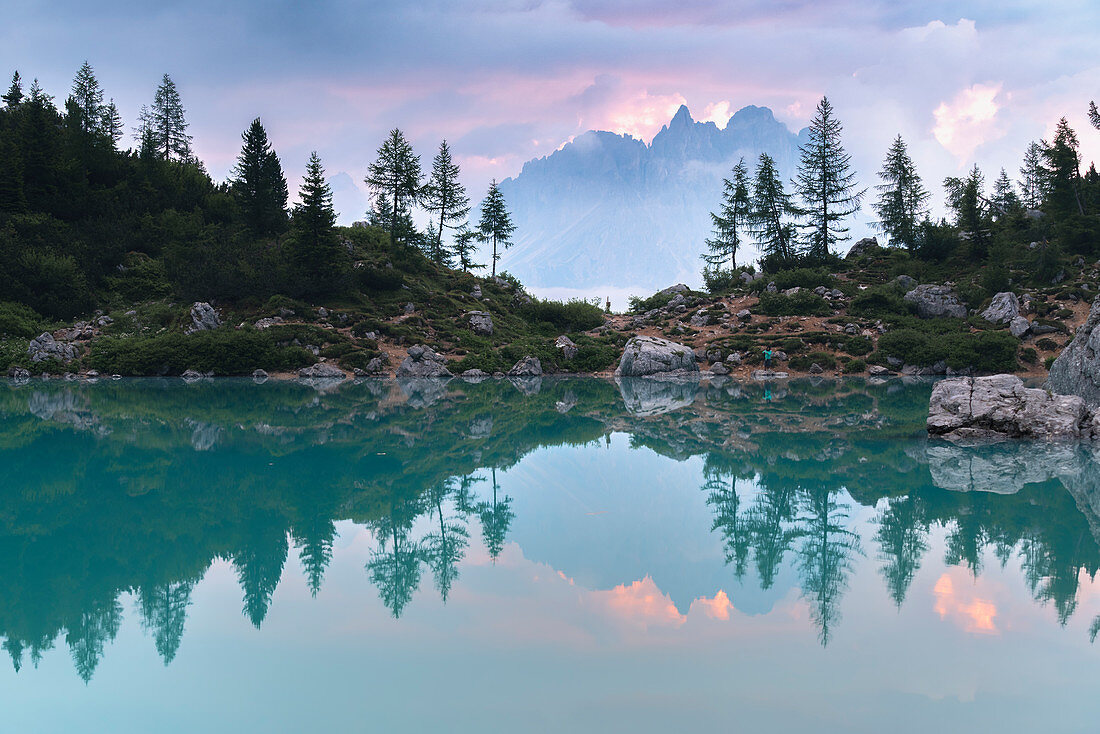 Cadini di Misurina surrounded by clouds reflect on the surface of Lake Sorapis. Cortina d'Ampezzo, Belluno province, Veneto, Italy.