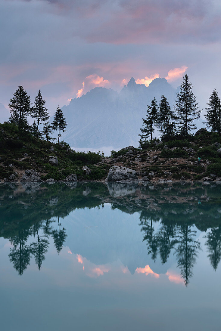 Cadini di Misurina surrounded by clouds reflect on the surface of Lake Sorapis. Cortina d'Ampezzo, Belluno province, Veneto, Italy.