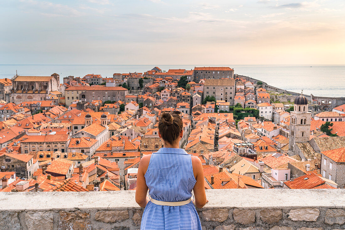 Frau betrachtet von alten Mauern die roten Dächer der Stadt, Dubrovnik, Gespanschaft Dubrovnik-Neretva, Kroatien