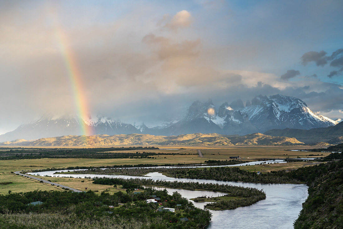 Paine Horns, Cerro Paine Grande and Cerro Paine at dawn, with  rainbow and Serrano river in the foreground. Torres del Paine National Park, Ultima Esperanza province, Magallanes region, Chile.