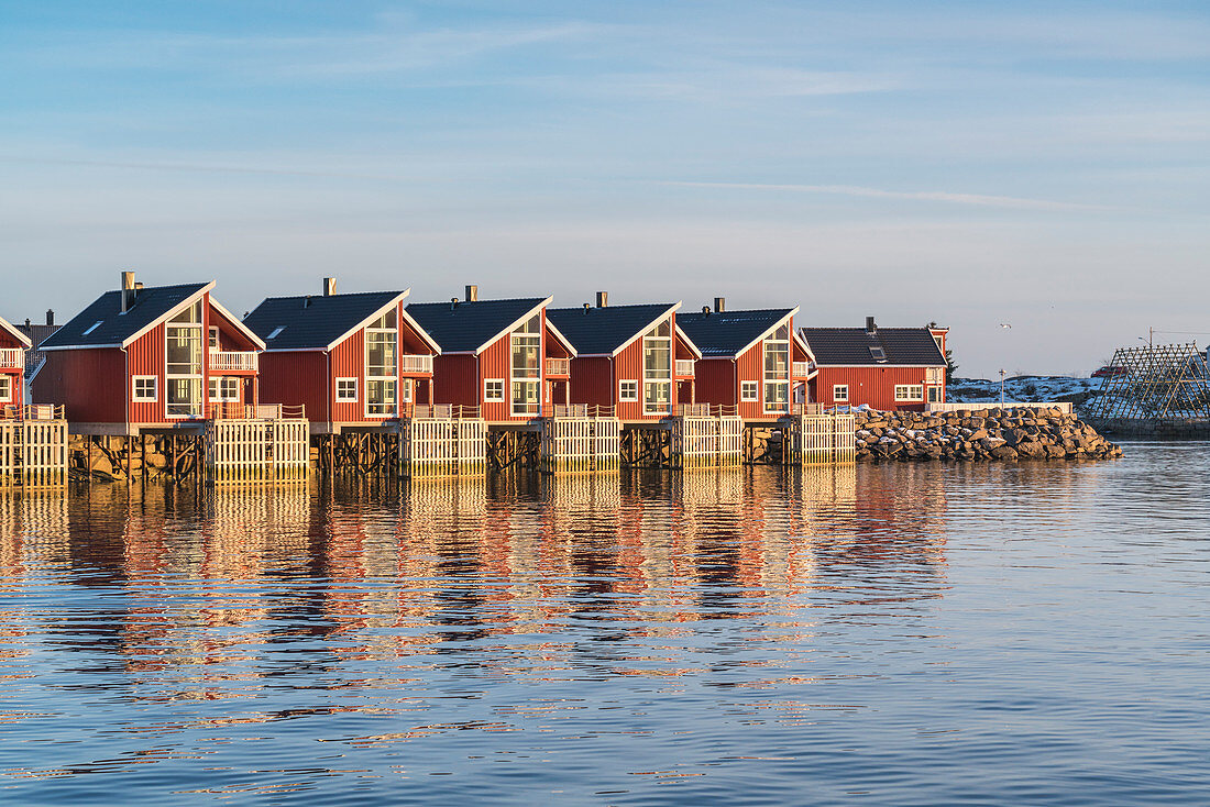 Traditionelle rote Häuser bei Sonnenuntergang im Winter, Henningsvaer, Nordland, Region Nordnorwegen, Norwegen