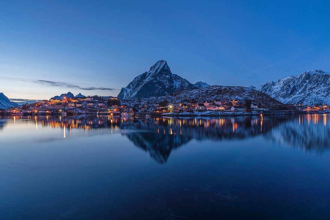 Bucht von Reine in der Abenddämmerung im Winter, mit Olstinden-Gipfel im Hintergrund, Reine, Nordland, Nordnorwegen, Norwegen