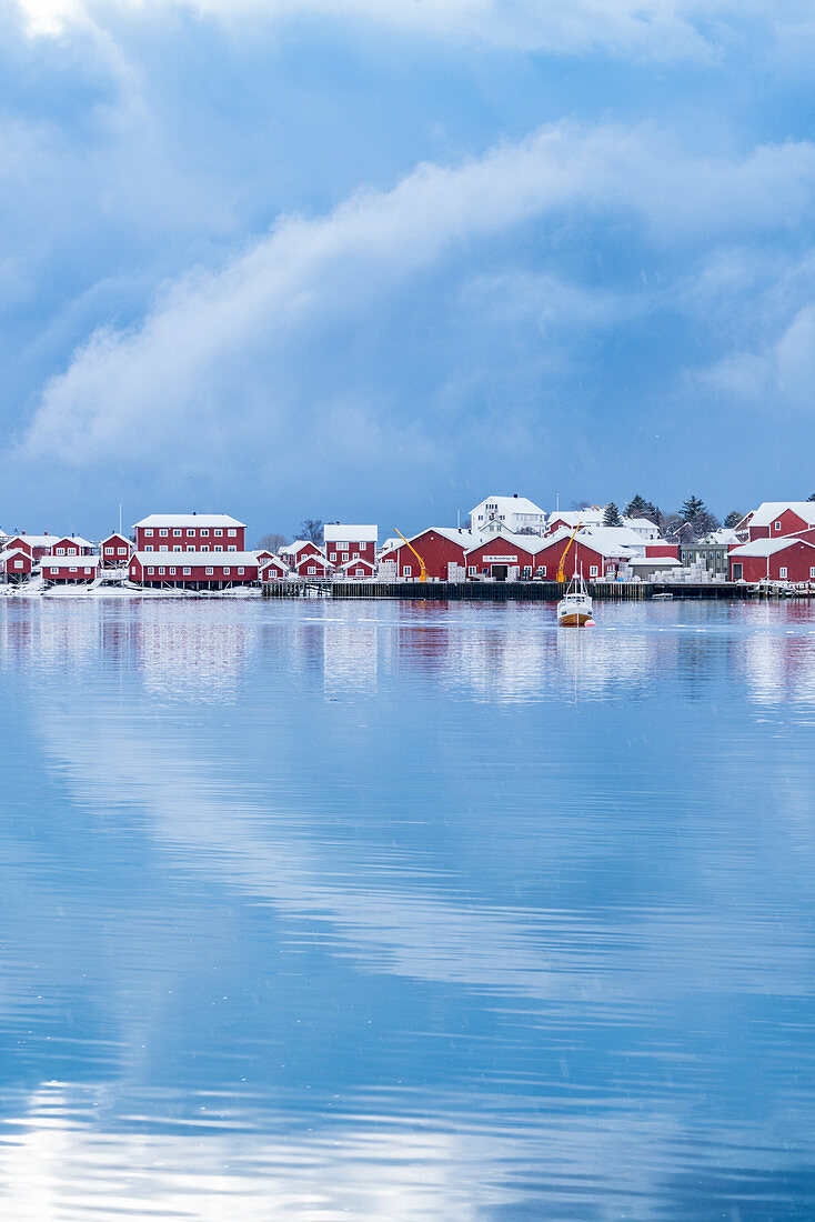 Traditionelle 'Rorbu'-Häuser spiegeln sich im Winter auf dem Fjord wider, Reine, Lofoten, Nordland, Nordnorwegen, Norwegen