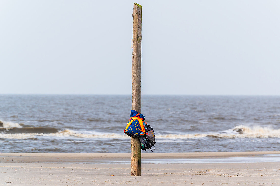 Backpacks hang on a pole in the North Sea, St. Peter-Ording, North Sea, North Friesland, Germany
