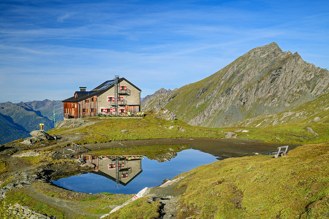 Sudetendeutsche Hütte spiegelt sich in Bergsee, Nussingkogel im Hintergrund, Granatspitzgruppe, Nationalpark Hohe Tauern, Osttirol, Österreich