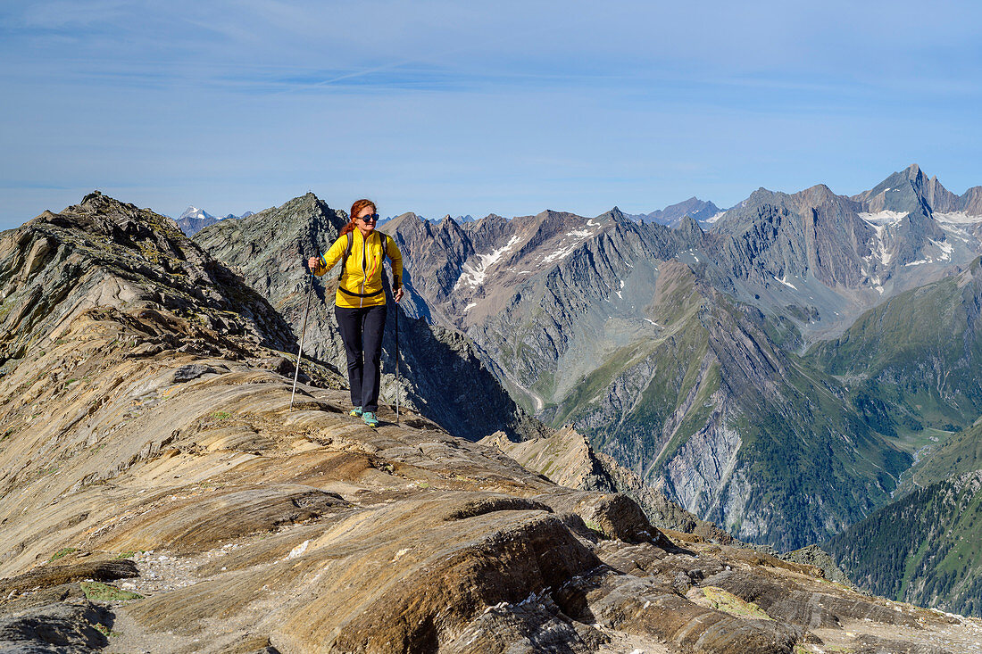 Woman hiking climbs over rocks to the Großer Muntanitz, Großer Muntanitz, Granatspitzgruppe, Hohe Tauern, Hohe Tauern National Park, East Tyrol, Austria