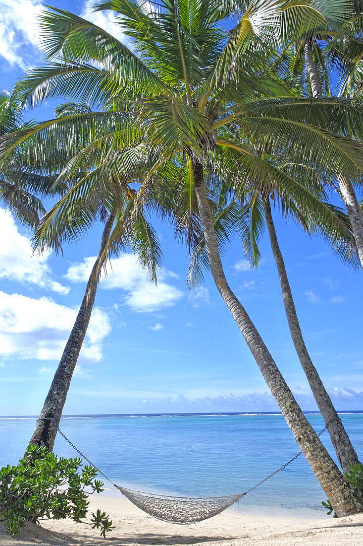 An empty hammock on Titikaveka beach in Rarotonga, Cook Islands.