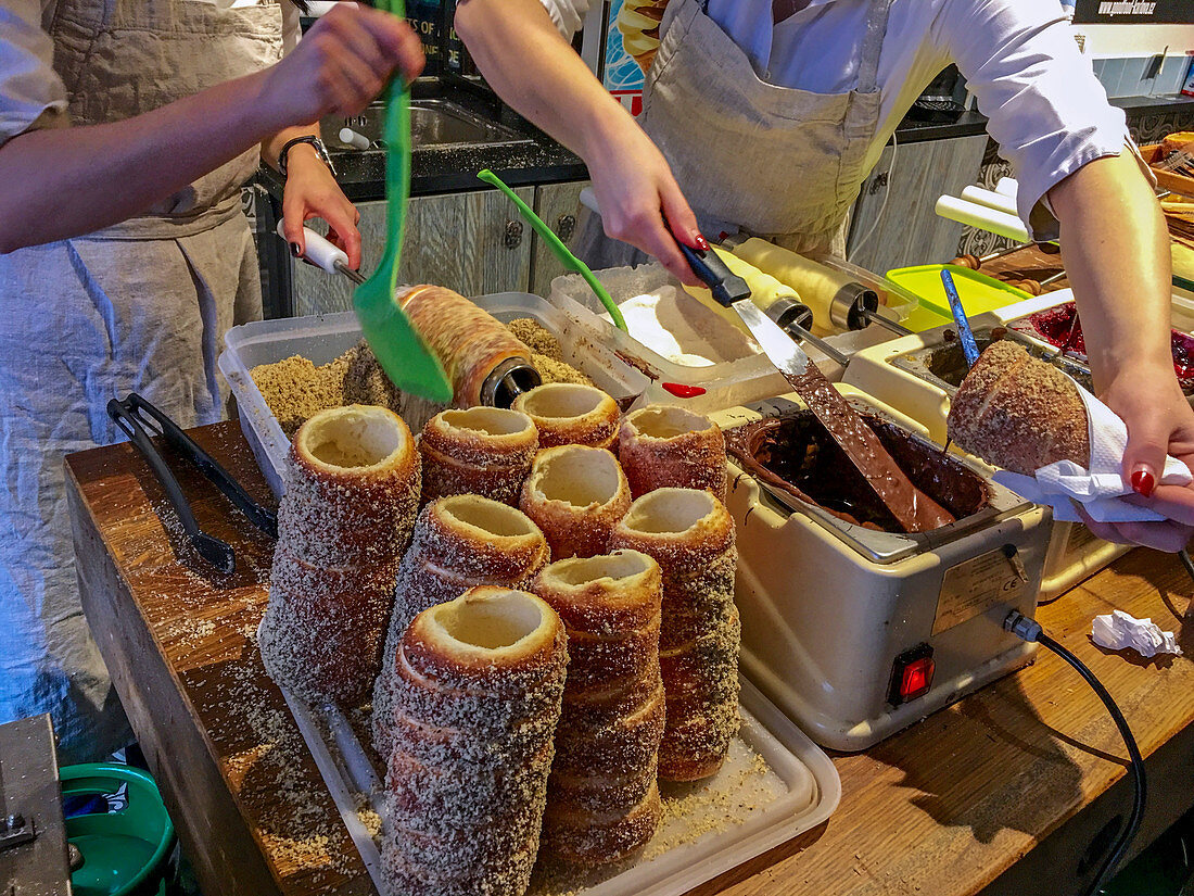 Trdelník is a kind of spit cake. It is made from rolled dough that is wrapped around a stick, then grilled and topped with sugar and walnut mix. Trdelník is found in several Central European countries, most prominently Austria, Czech Republic, Slovakia and Hungary (where it is known to come from the Hungarian-speaking part of Transylvania, Romania). The word "trdelník" is of Czech or Slovak origin. Nowadays, trdelník is very popular among tourists as a sweet pastry in the Czech Republic. A modern version filled with ice cream or other fillings, has been spreading recently from Prague, the Czec