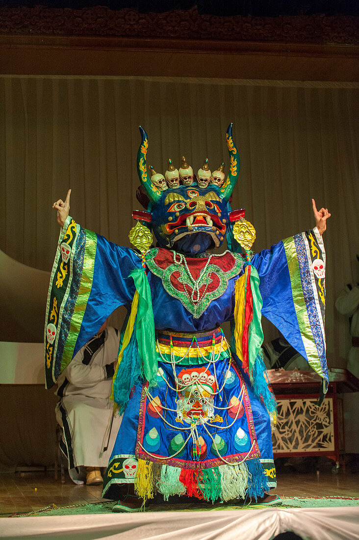 Eine Tänzerin, die ein traditionelles Kostüm und eine traditionelle Maske während einer kulturellen Aufführung in Ulaanbaatar, Mongolei trägt.