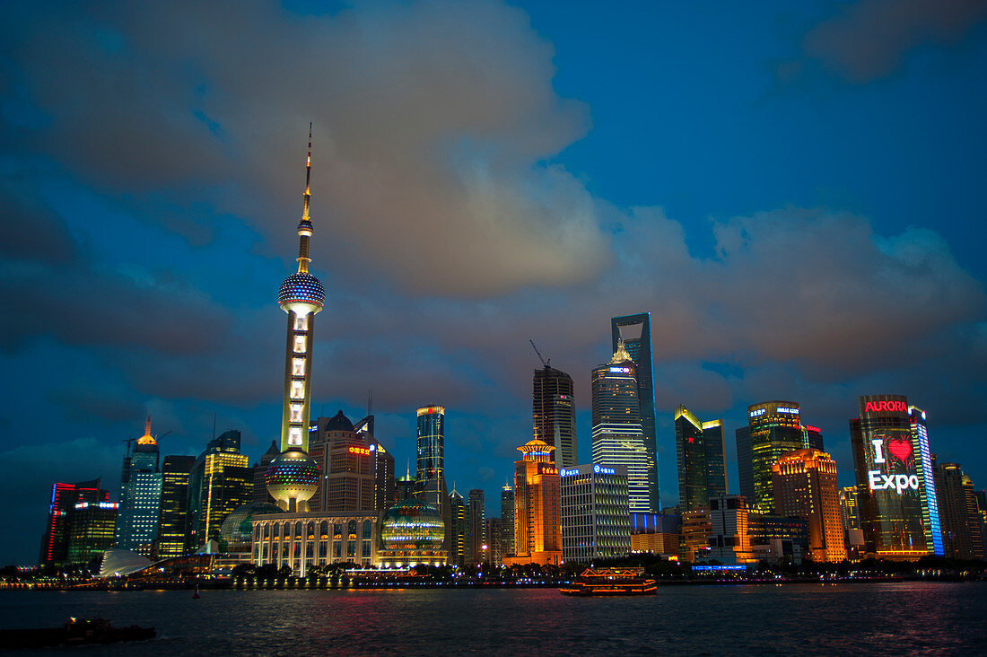 Blick vom Bund bei Nacht auf den Huangpu-Fluss, das 492 Meter hohe World Financial Center und den Oriental Pearl-Fernsehturm in Pudong, Shanghai, China.