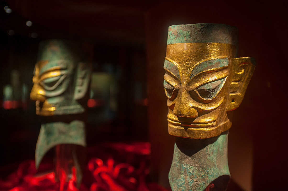A bronze human head with gold mask from the 12th century BC in the exhibit of ancient artifacts at the Sanxingdui Museum in Sanxingdui near Chengdu, Sichuan Province in China.