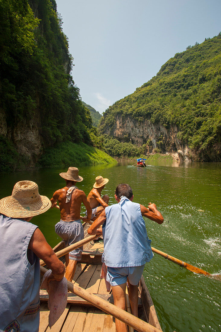 Chinese men rowing a traditional Sampan boat near Badong on the Shennong stream, a tributary of the Yangtze River at the Wu Gorge (Three Gorges) in China.