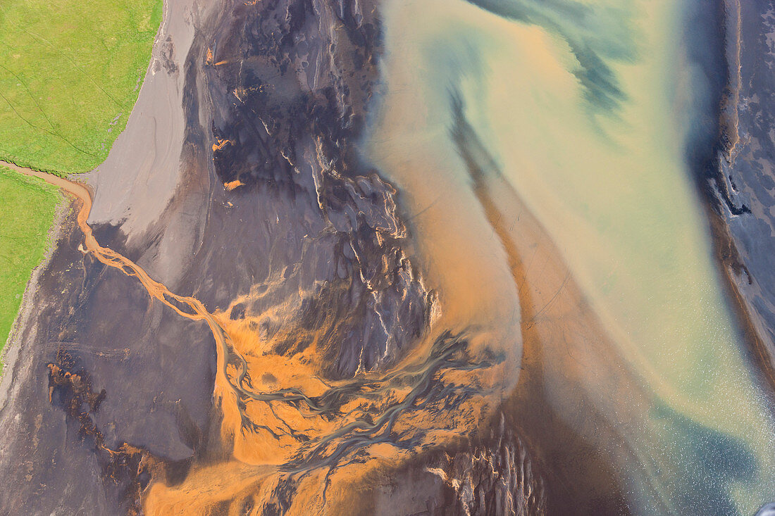 Luftaufnahme des vom Abfluss gefärbten Flussdeltas bei Hvammur, Island