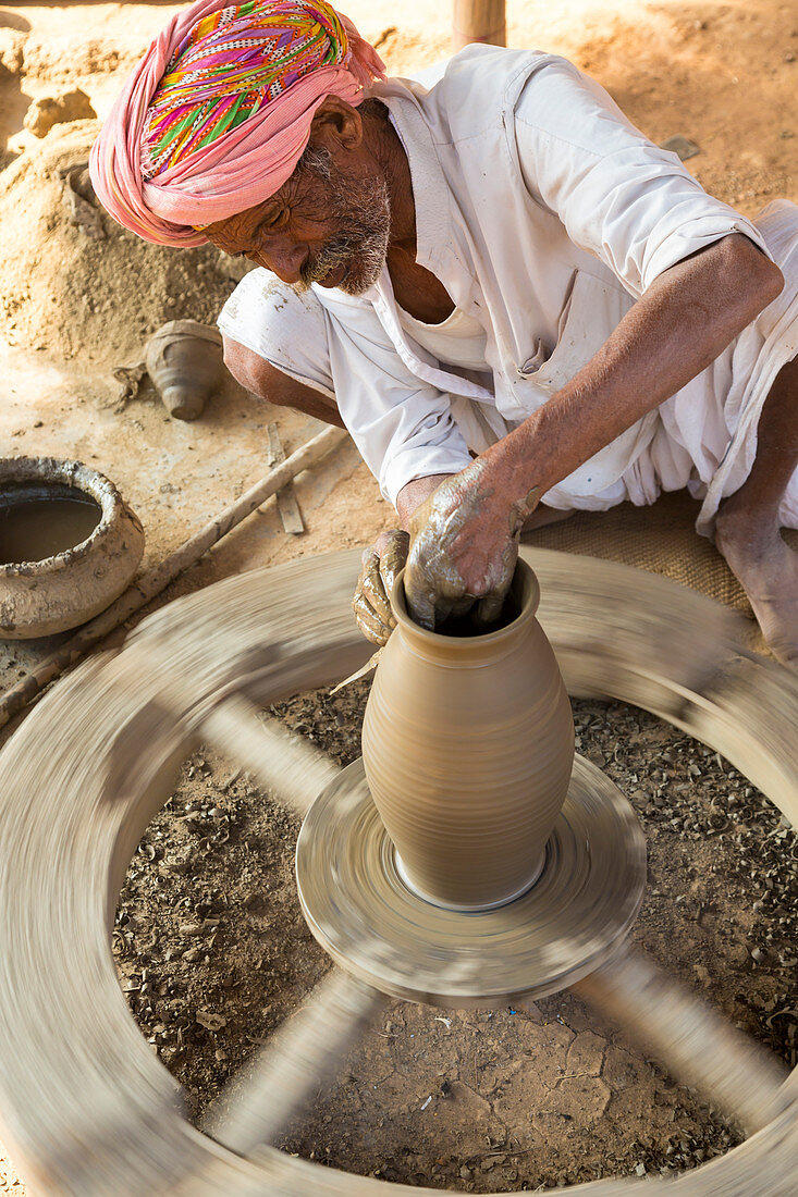 Töpfer mit Topf auf Drehscheibe, Udaipur, Rajasthan, Indien
