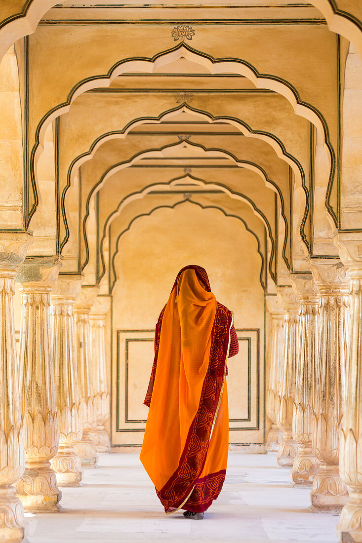 Indische Frau, die entlang Durchgang, Amber Fort, Jaipur, Rajasthan, Indien geht. Modell freigegeben.