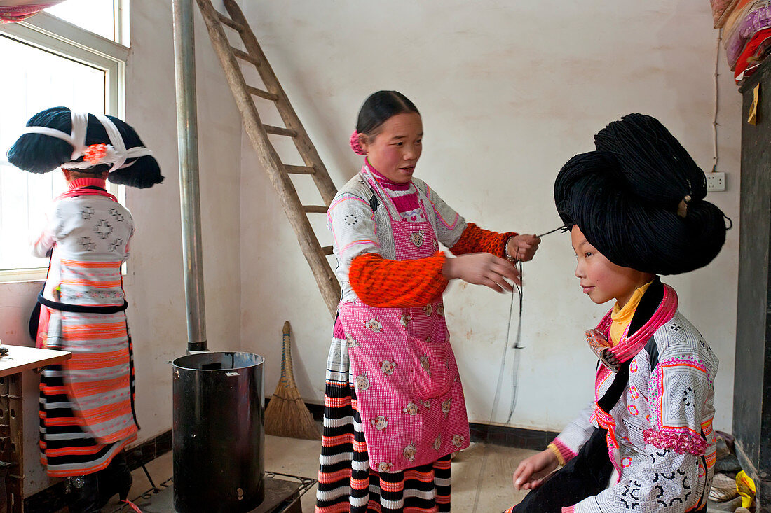 Langhorn Miao Frau, bereitet den Kopfschmuck eines Mädchens vor, Sugao, China