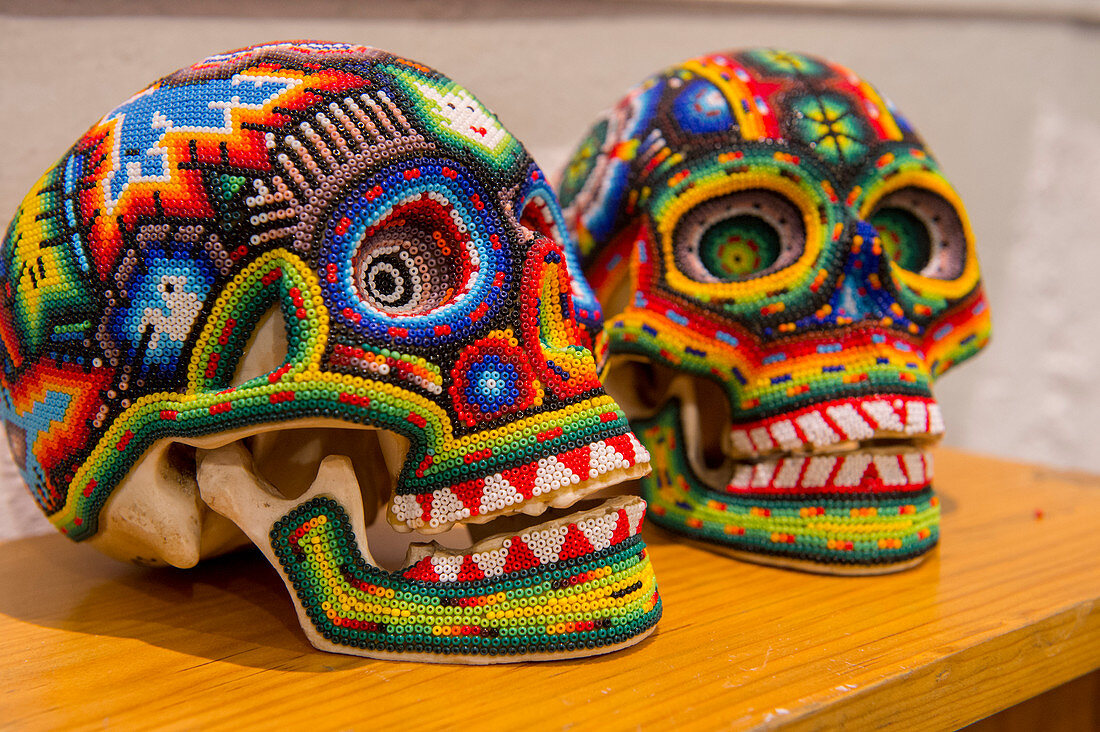 Mit Glasperlen bedeckte Schädel, ausgestellt in einer Kunstgalerie in Oaxaca City, Mexiko.
