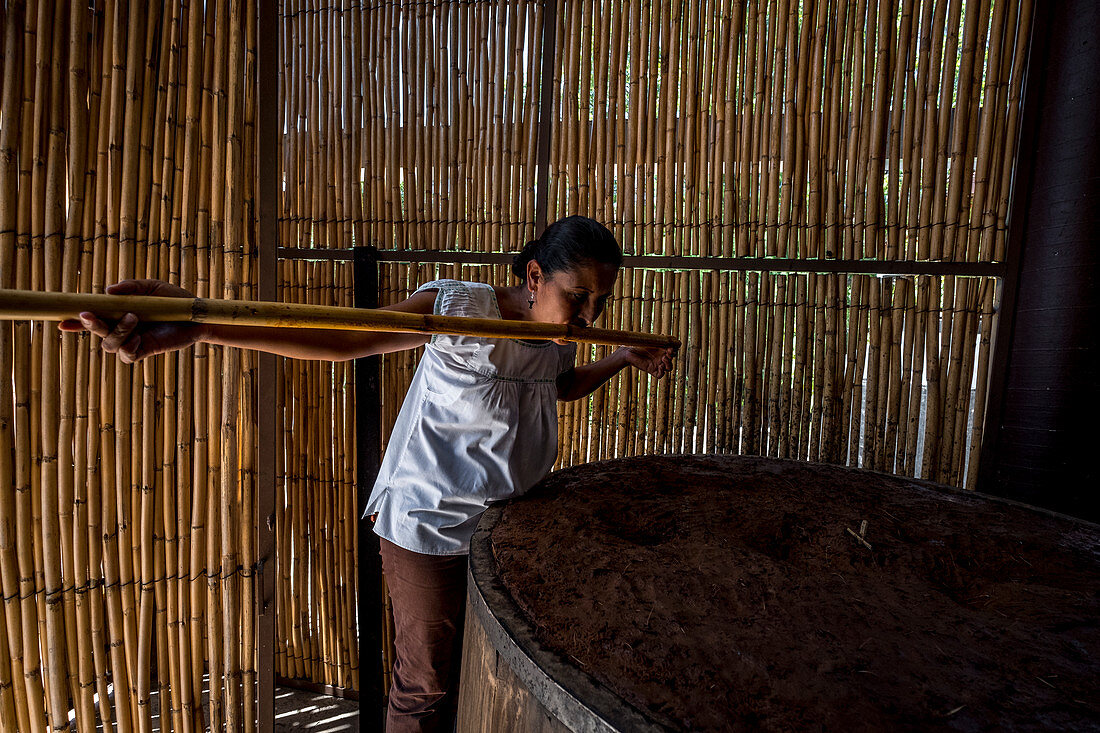 Fachkundige Frau testet ihren Mezcal in einer Brennerei im Bundesstaat Oaxaca in Mexiko