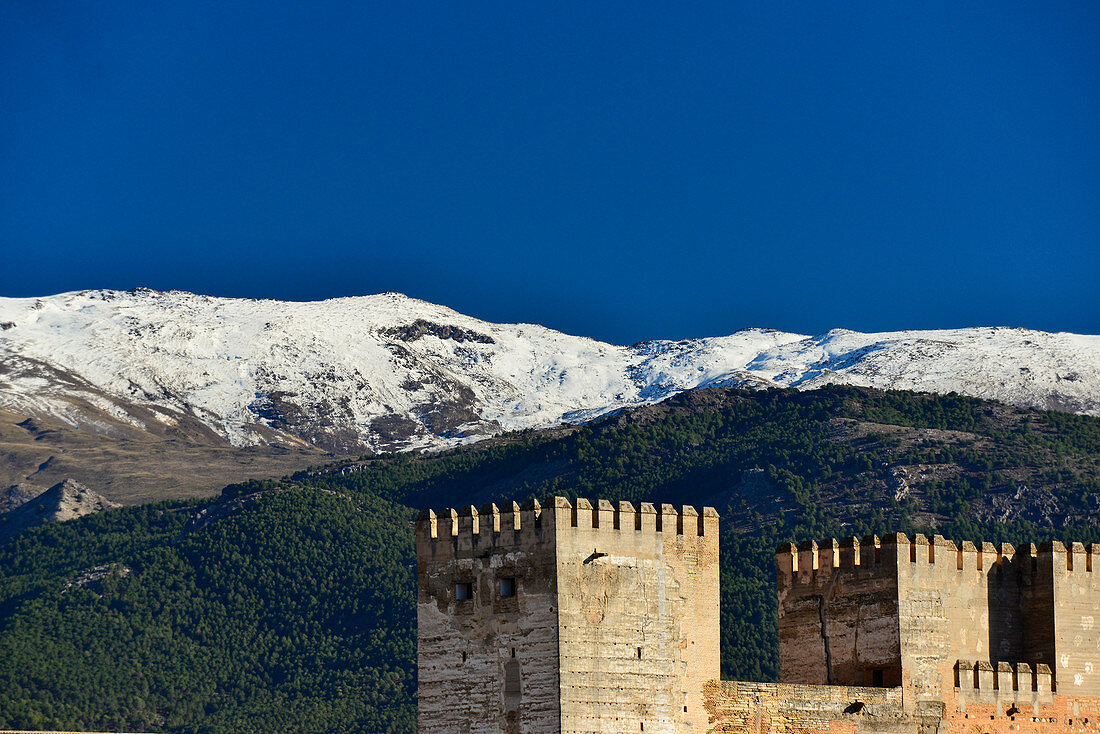 View of the defense towers of the Alhambra and the Sierra Nevada in the background, Granada, Andalusia, Spain