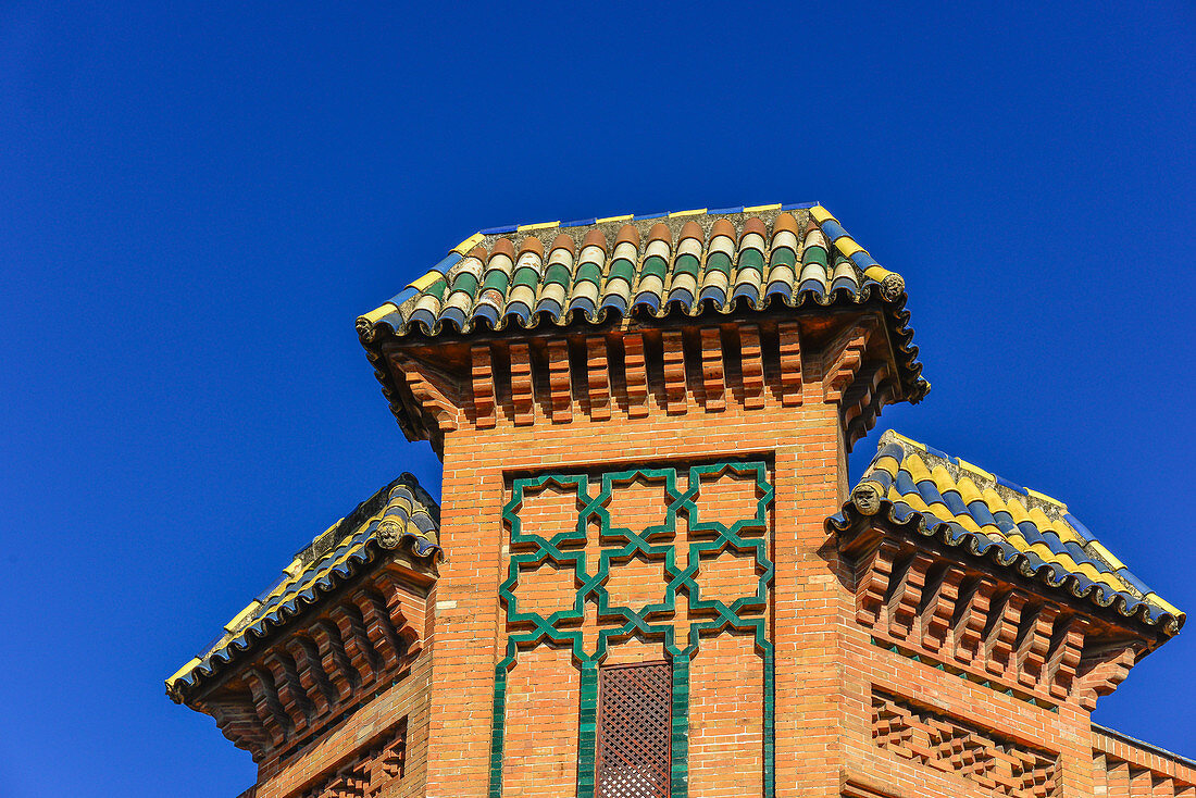 Kunstvoll verziertes Dach mit farbigen Dachziegeln vor tiefblauem Himmel, Sevilla, Andalusien, Spanien