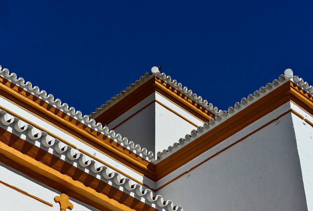 Weißes Haus mit farbigen Akzenten im maurischen Stil vor azurblauem Himmel, bei Pilas, Andalusien, Spanien