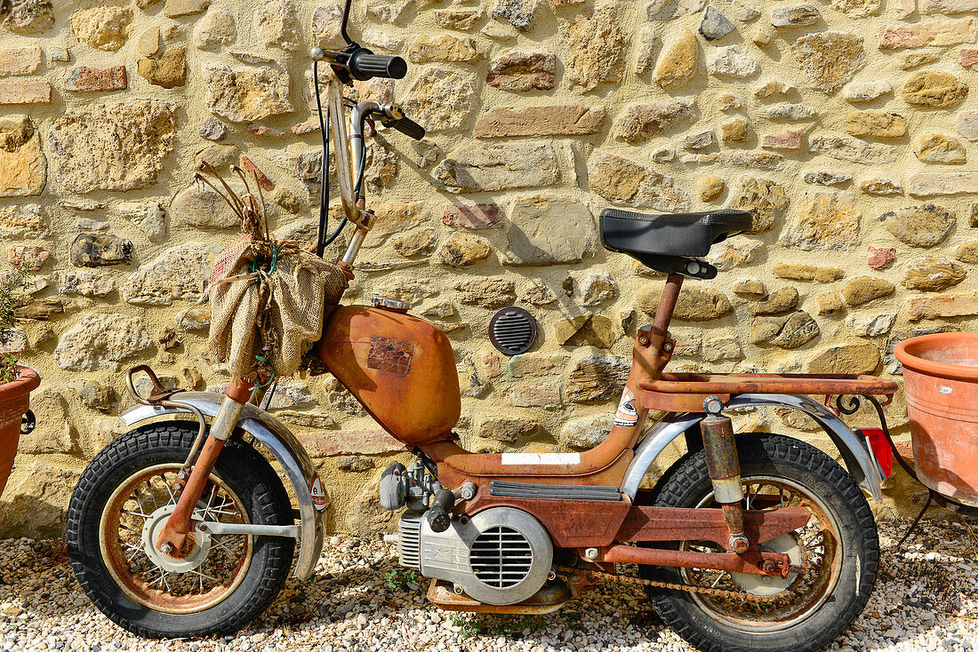 Old, rusty scooter on a stone house wall, Rustic campsite, Perugia, Italy