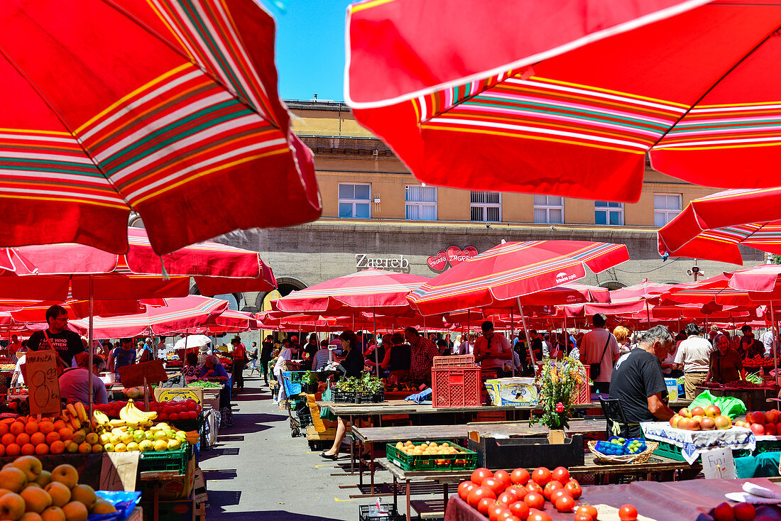 Der gut besuchte Obstmarkt mit roten Sonnenschirmen in Zagreb, Kroatien
