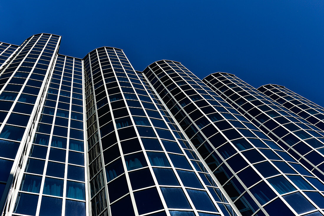 Futuristisches Bürogebäude mit verglaster Fassade vor tiefblauem Himmel, Zagreb, Kroatien