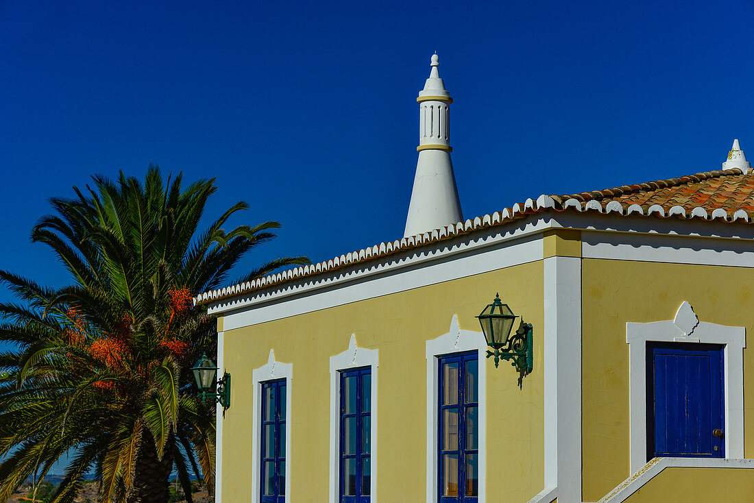 Typical, colorful house with palm tree in the Algarve, Luz, Portugal