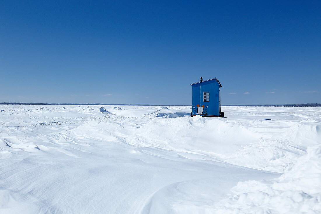 Kleine Holzhütte mit Schneeverwehungen auf dem Sankt Lorenz Strom im Winter, Quebec, Kanada