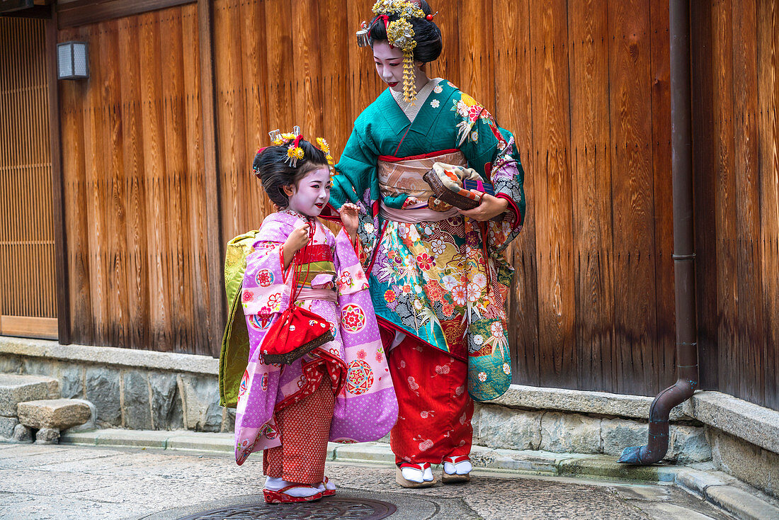Mother and young daughter dressed in traditional geisha Japanese dress, Kyoto, Japan